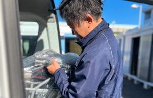 用品を車に積む男性